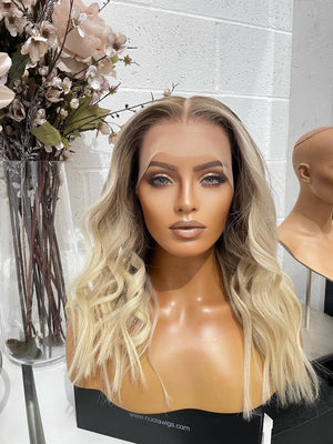 Model wearing blonde balayage 18-inch HD lace human hair wig in body wave texture – Nuola Wigs.