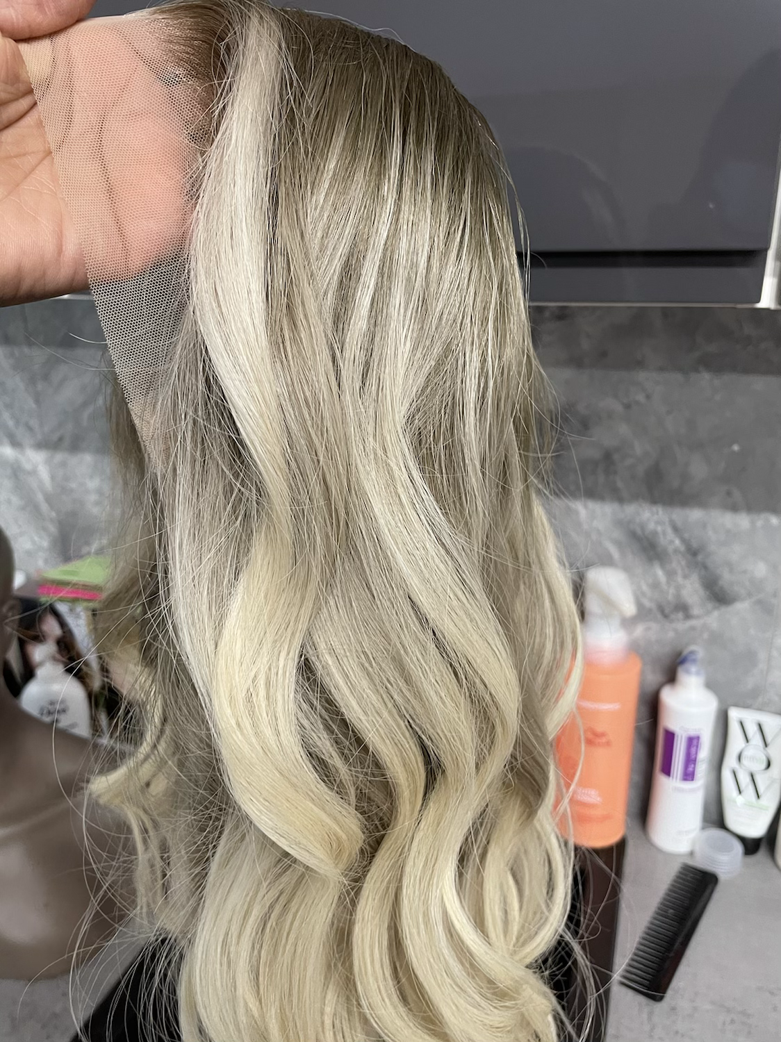 Model wearing blonde balayage 18-inch HD lace human hair wig in body wave texture – Nuola Wigs.