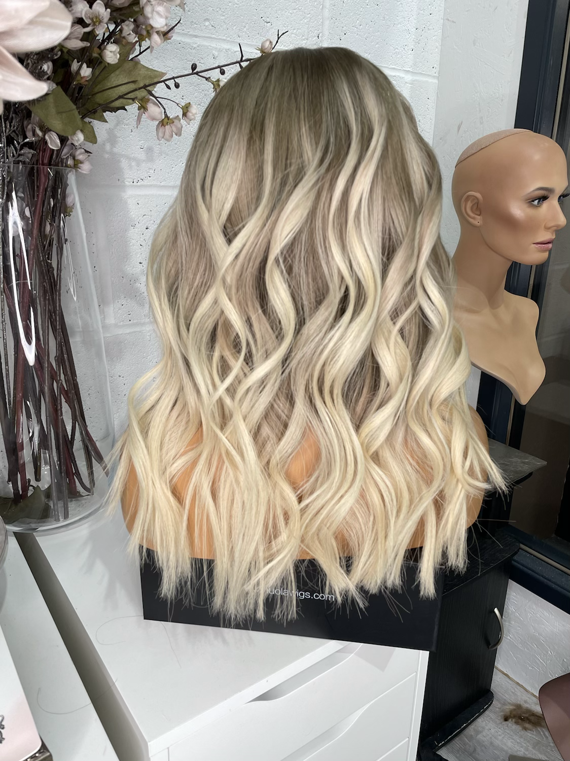 Model wearing blonde balayage 18-inch HD lace human hair wig in body wave texture – Nuola Wigs.