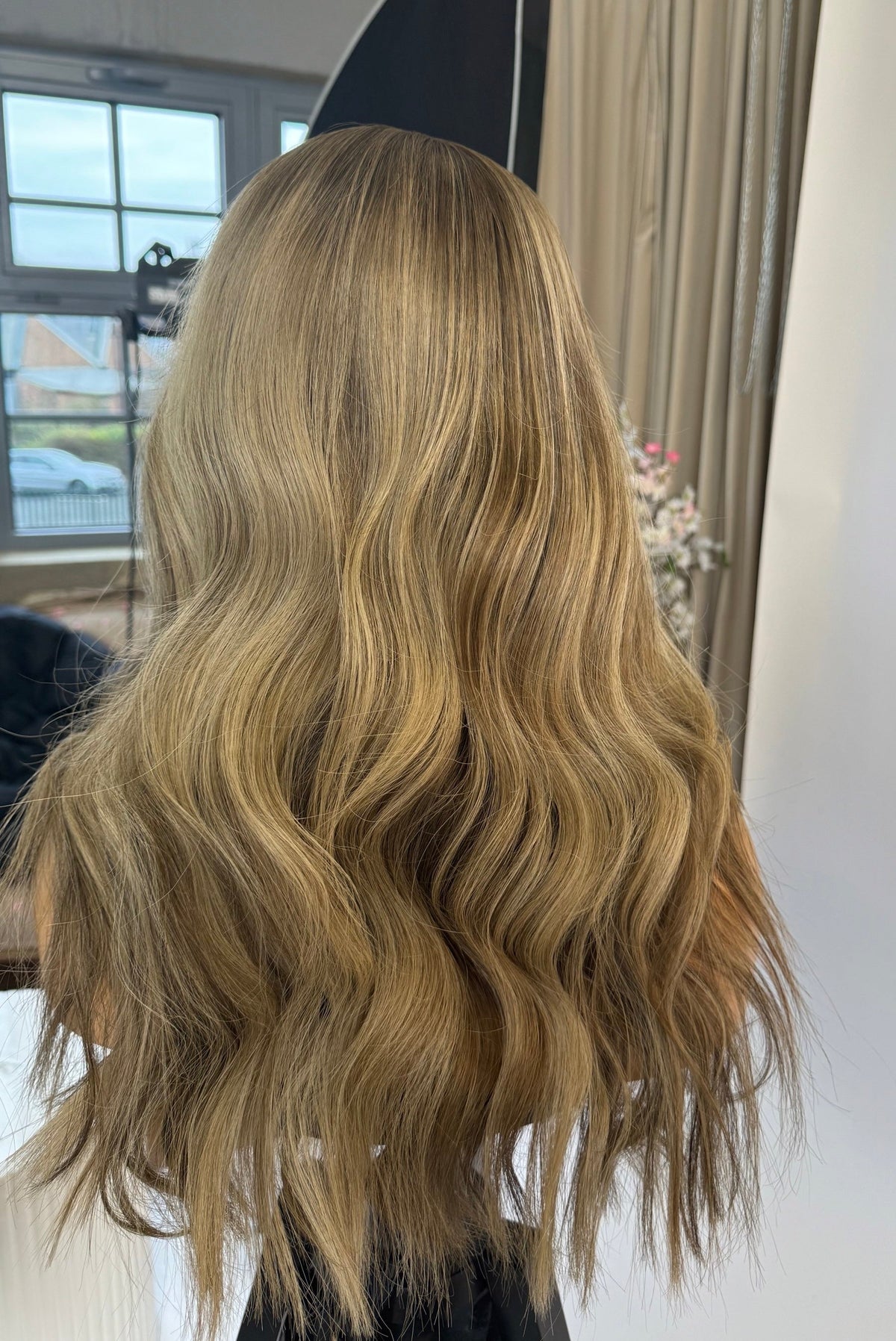 Model wearing blonde balayage 18-inch HD lace human hair wig in body wave texture – Nuola Wigs.