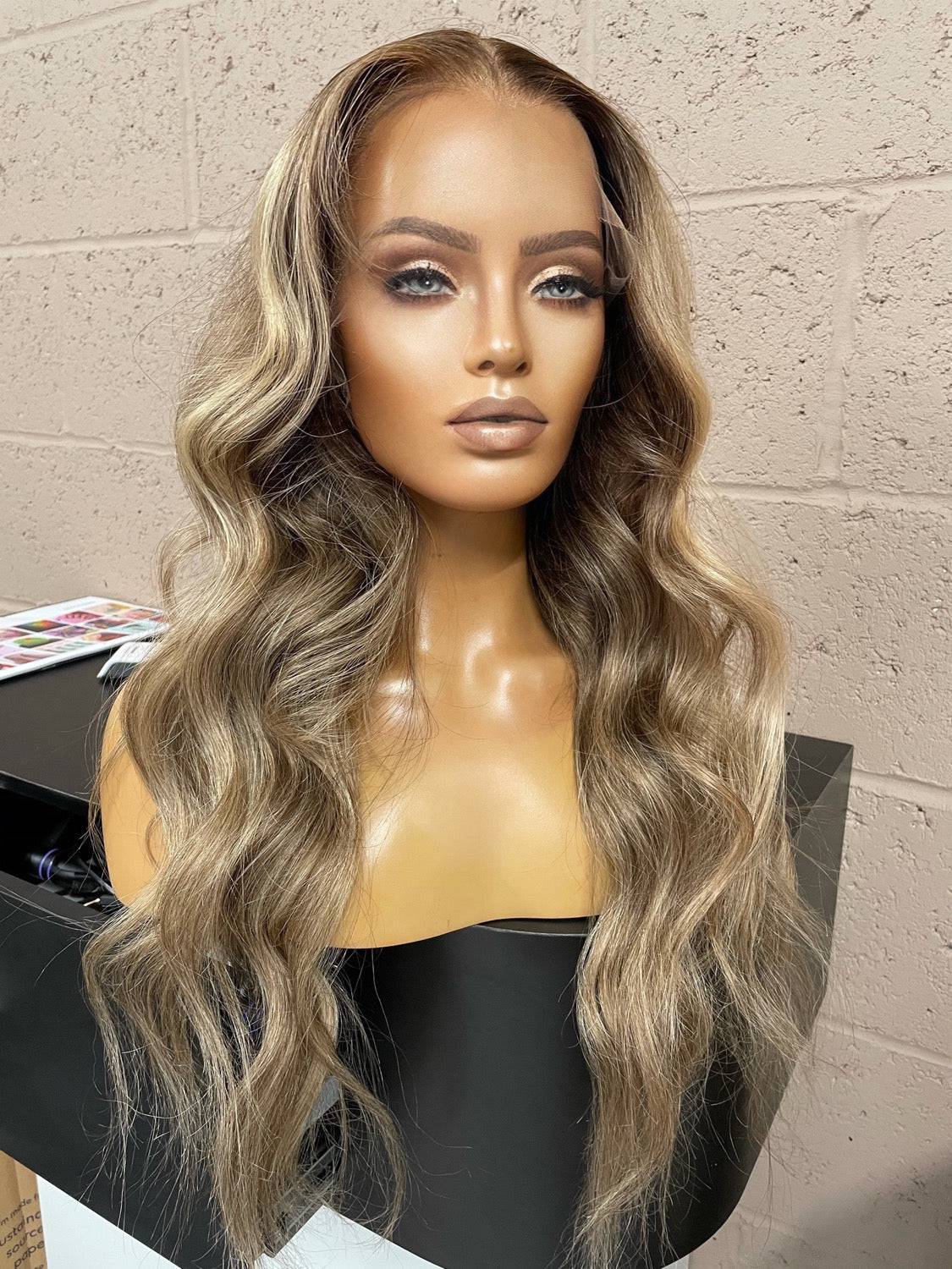 Model wearing blonde balayage 24-inch HD lace human hair wig in body wave texture – Nuola Wigs.