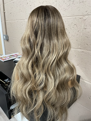 Model wearing blonde balayage 24-inch HD lace human hair wig in body wave texture – Nuola Wigs.