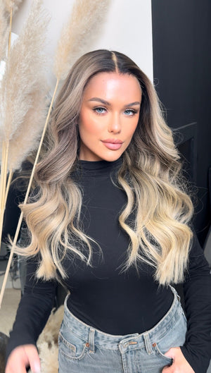 Model wearing blonde balayage 24-inch HD lace human hair wig in body wave texture – Nuola Wigs.