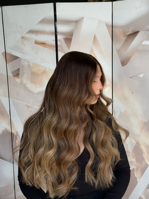 Model wearing blonde balayage 24-inch HD lace human hair wig in body wave texture – Nuola Wigs.