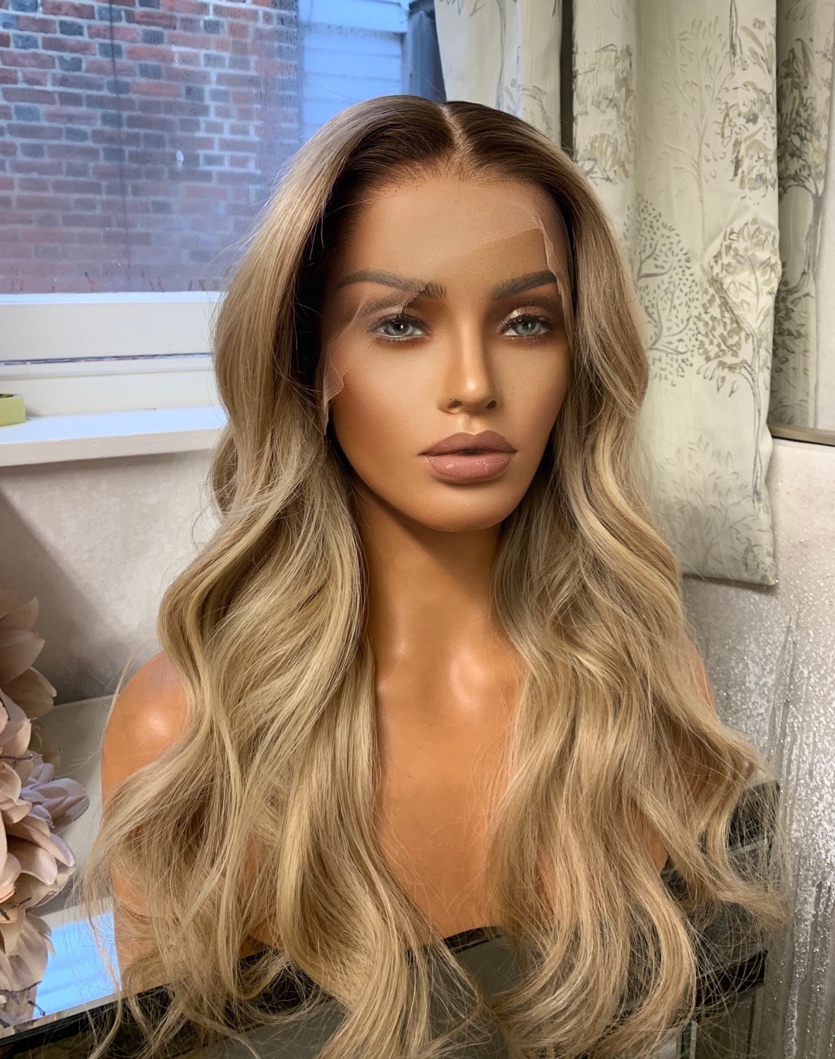 Model wearing blonde balayage 24-inch HD lace human hair wig in body wave texture – Nuola Wigs.