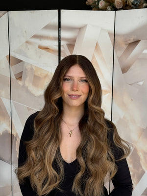 Model wearing blonde balayage 24-inch HD lace human hair wig in body wave texture – Nuola Wigs.