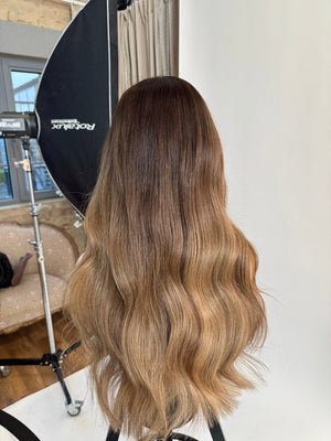 Model wearing blonde balayage 24-inch HD lace human hair wig in body wave texture – Nuola Wigs.