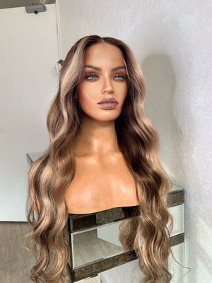 Model wearing blonde balayage 26-inch HD lace human hair wig in body wave texture – Nuola Wigs.