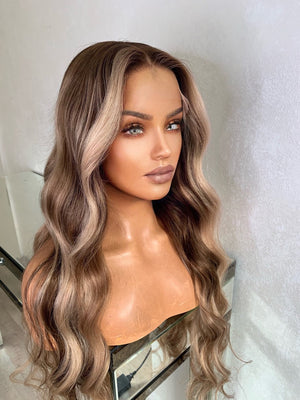 Model wearing blonde balayage 26-inch HD lace human hair wig in body wave texture – Nuola Wigs.