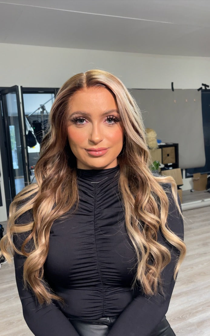 Model wearing blonde balayage 26-inch HD lace human hair wig in body wave texture – Nuola Wigs.