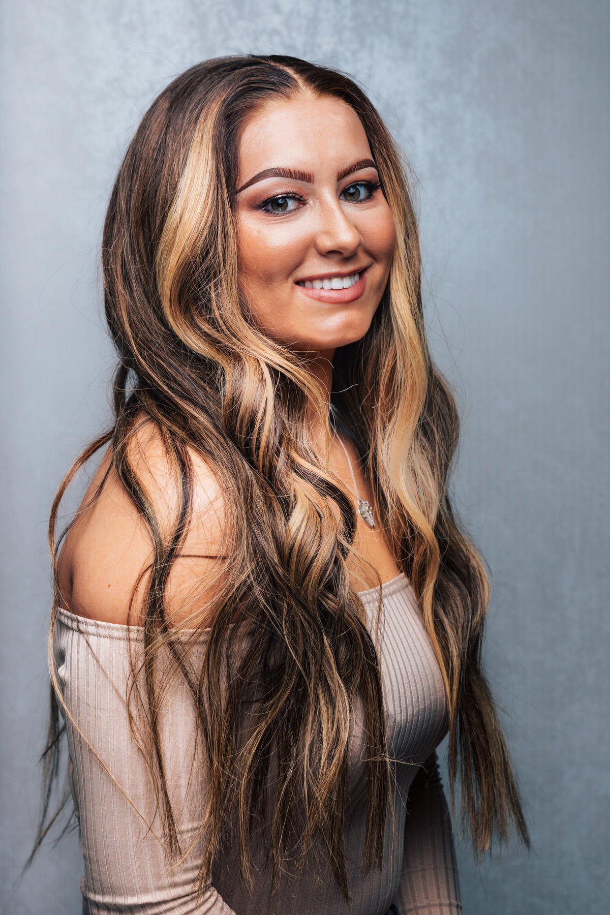 Model wearing brown balayage 22-inch HD lace human hair wig in body wave texture – Nuola Wigs.