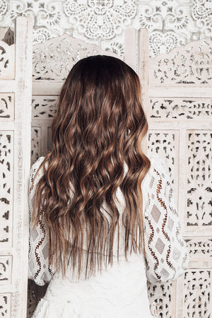 Model wearing brown balayage 22-inch HD lace human hair wig in body wave texture – Nuola Wigs.