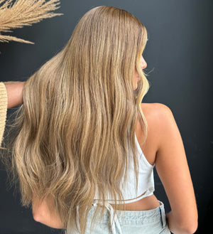 Model wearing brown balayage 24-inch HD lace human hair wig in body wave texture – Nuola Wigs.