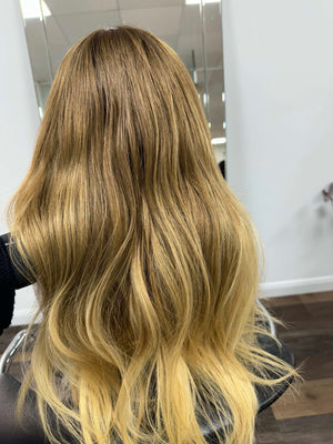 Child wearing a long blonde straight human hair wig, styled naturally,
against a white background – Nuola Wigs.
