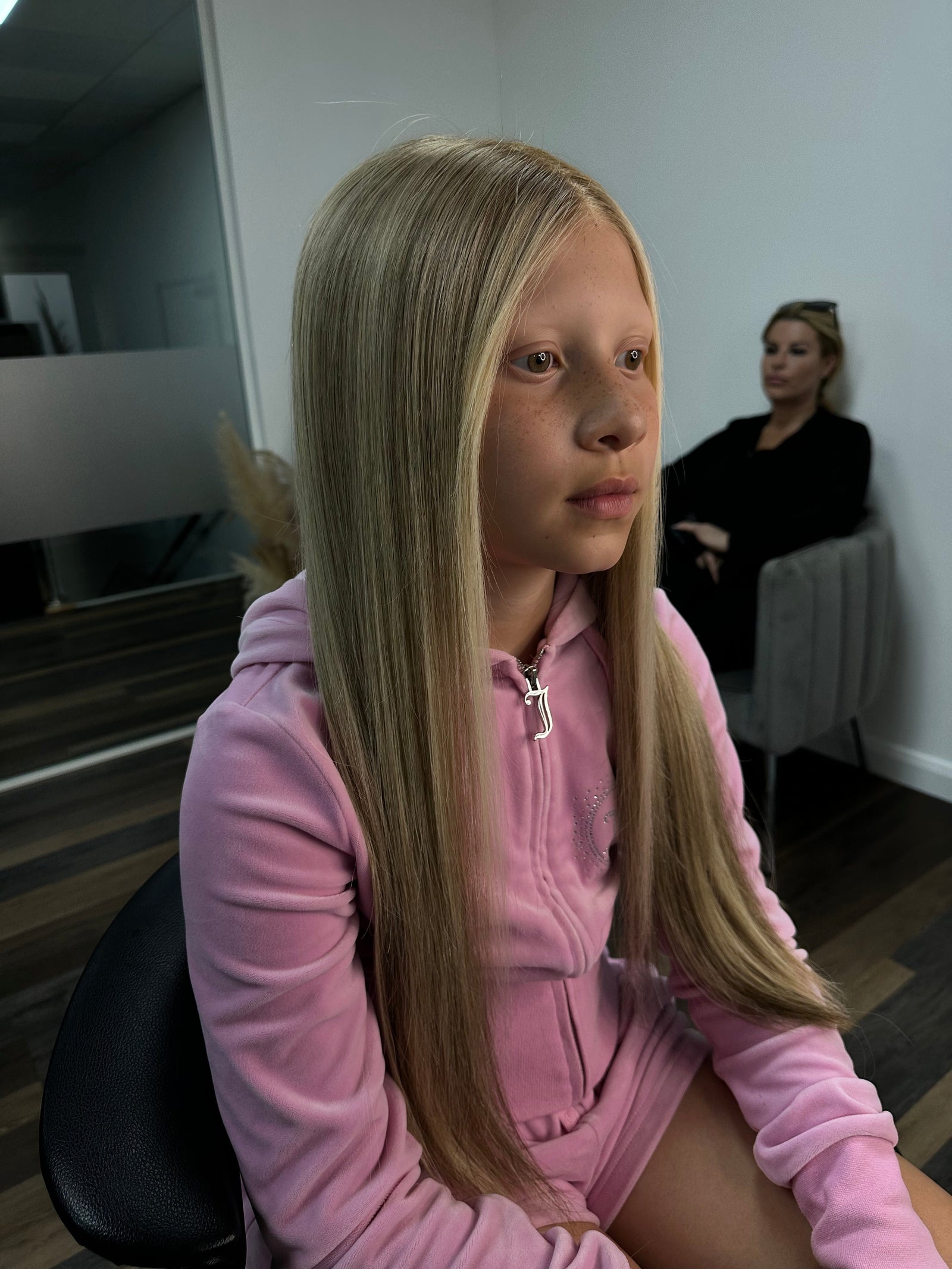 Child wearing a long blonde straight human hair wig, styled naturally,
against a white background – Nuola Wigs.