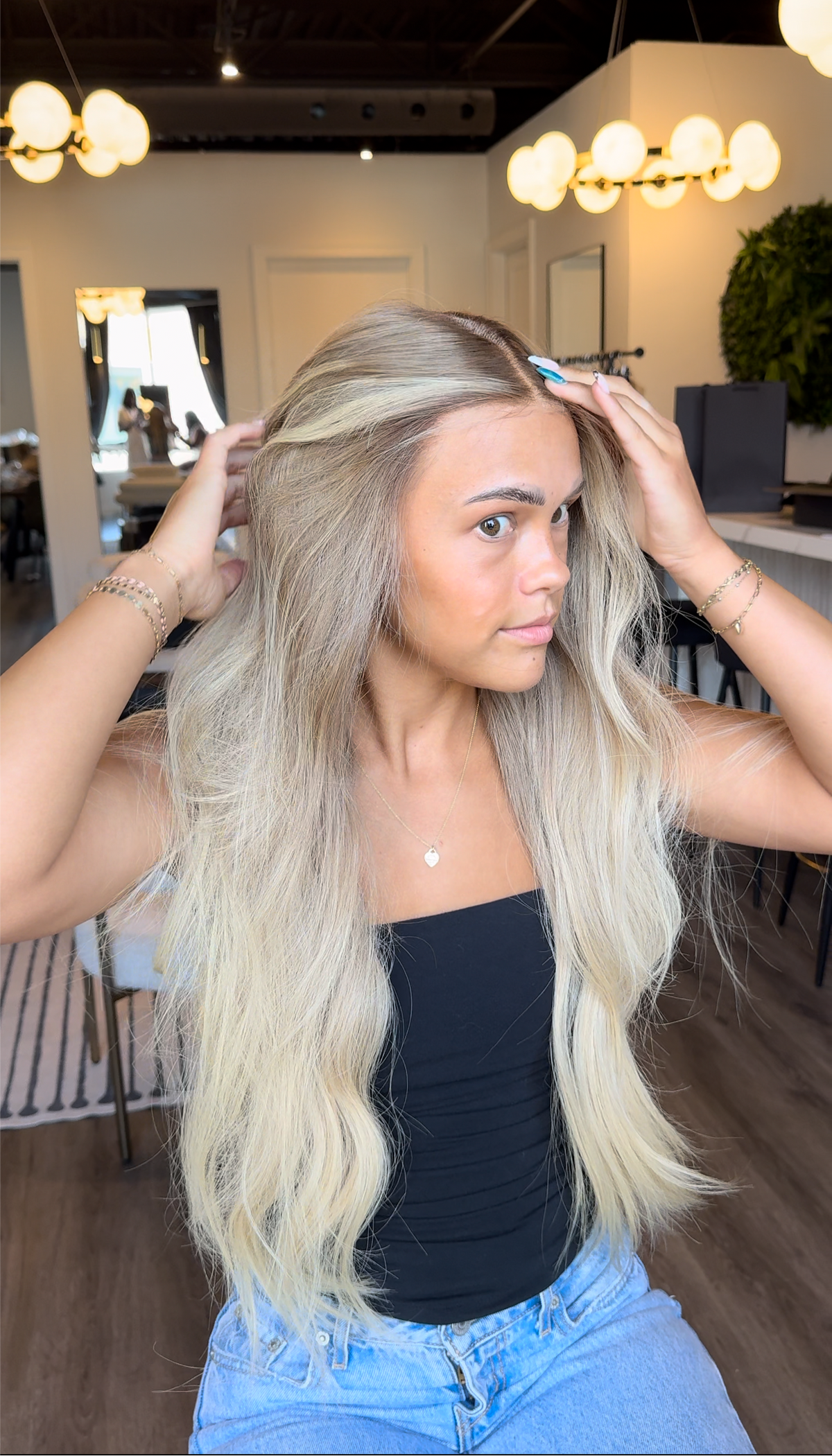 Model wearing blonde balayage 26-inch HD lace human hair wig in body wave
texture – Nuola Wigs.