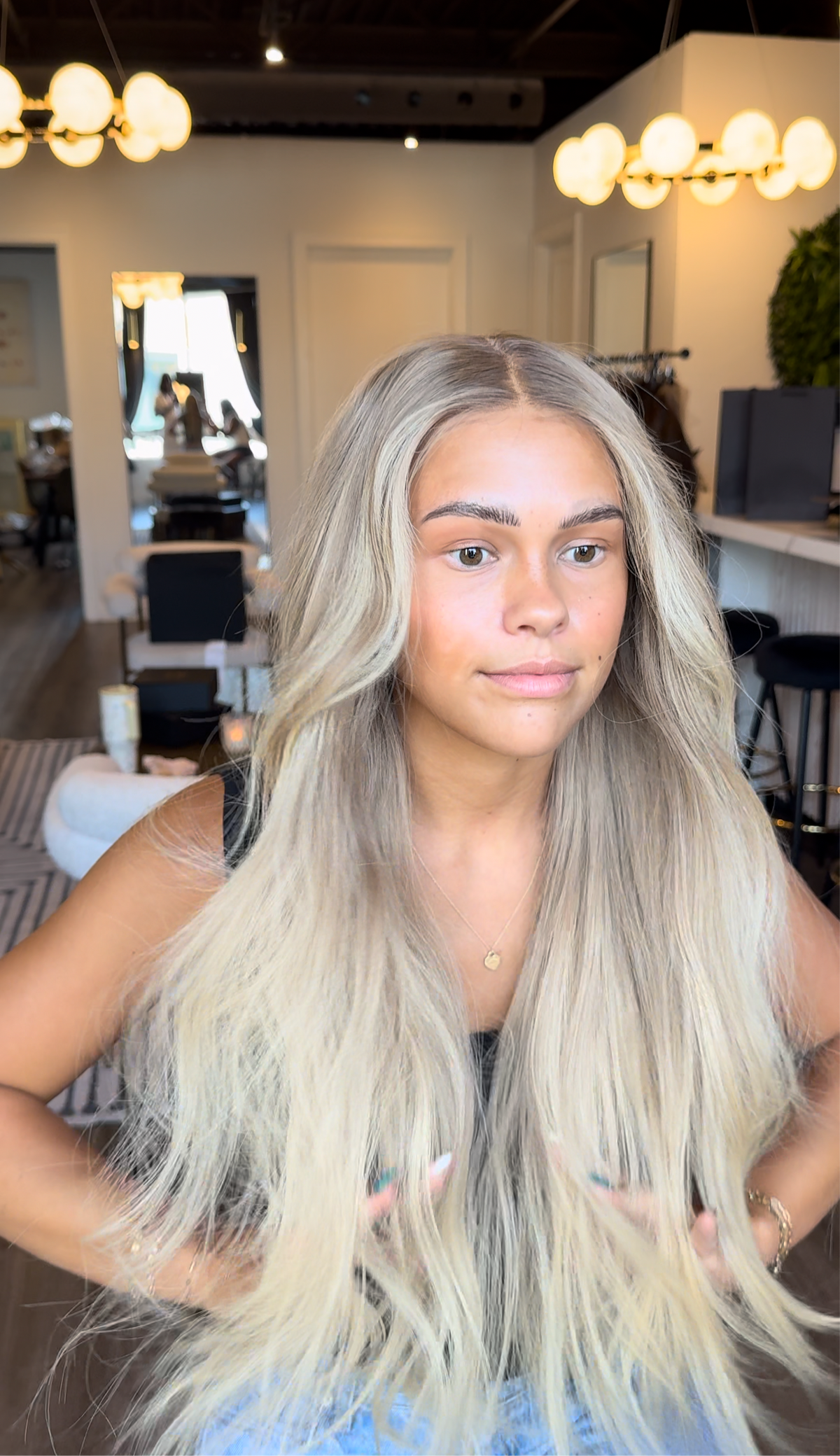 Model wearing blonde balayage 26-inch HD lace human hair wig in body wave
texture – Nuola Wigs.