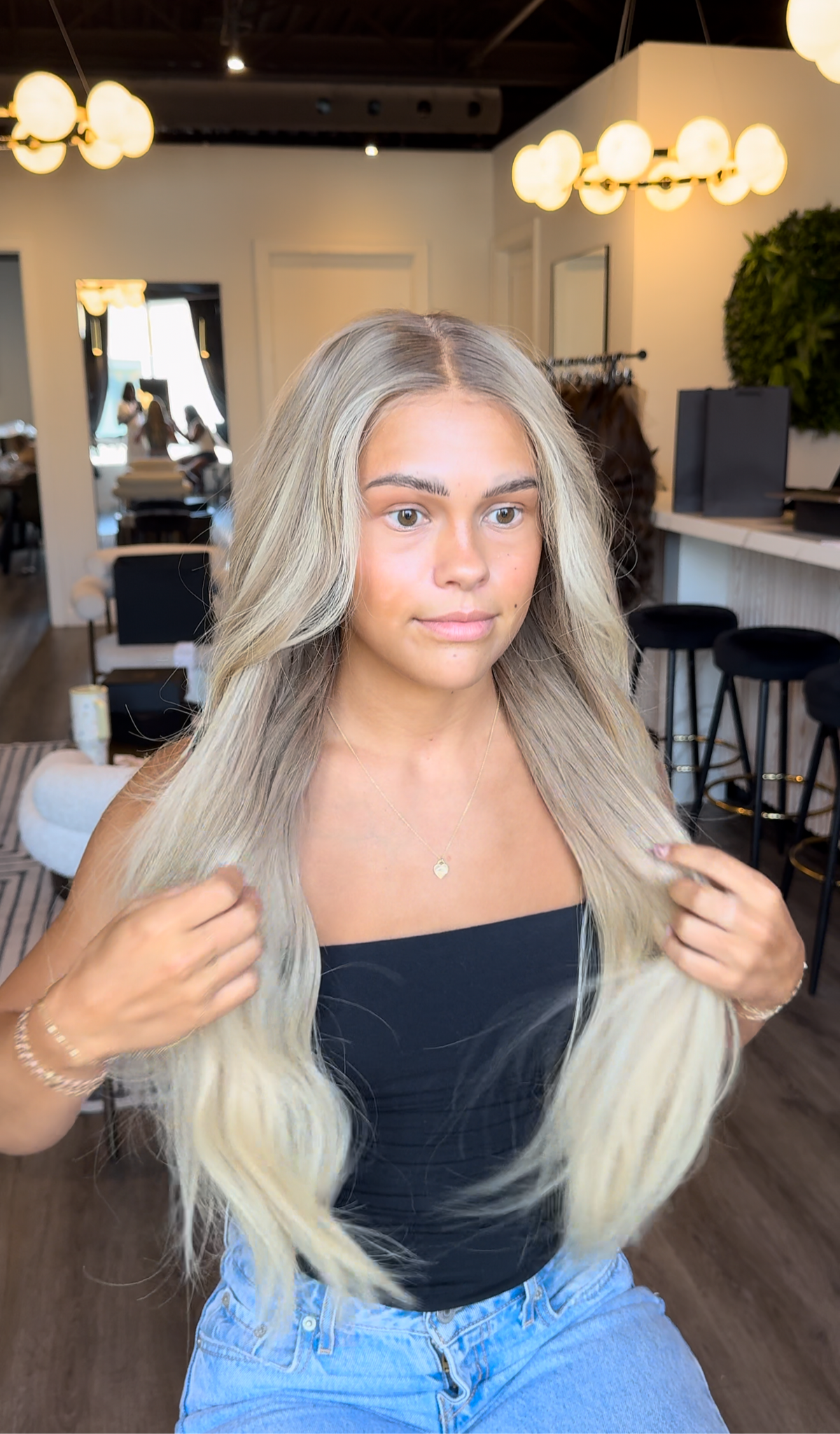 Model wearing blonde balayage 26-inch HD lace human hair wig in body wave
texture – Nuola Wigs.