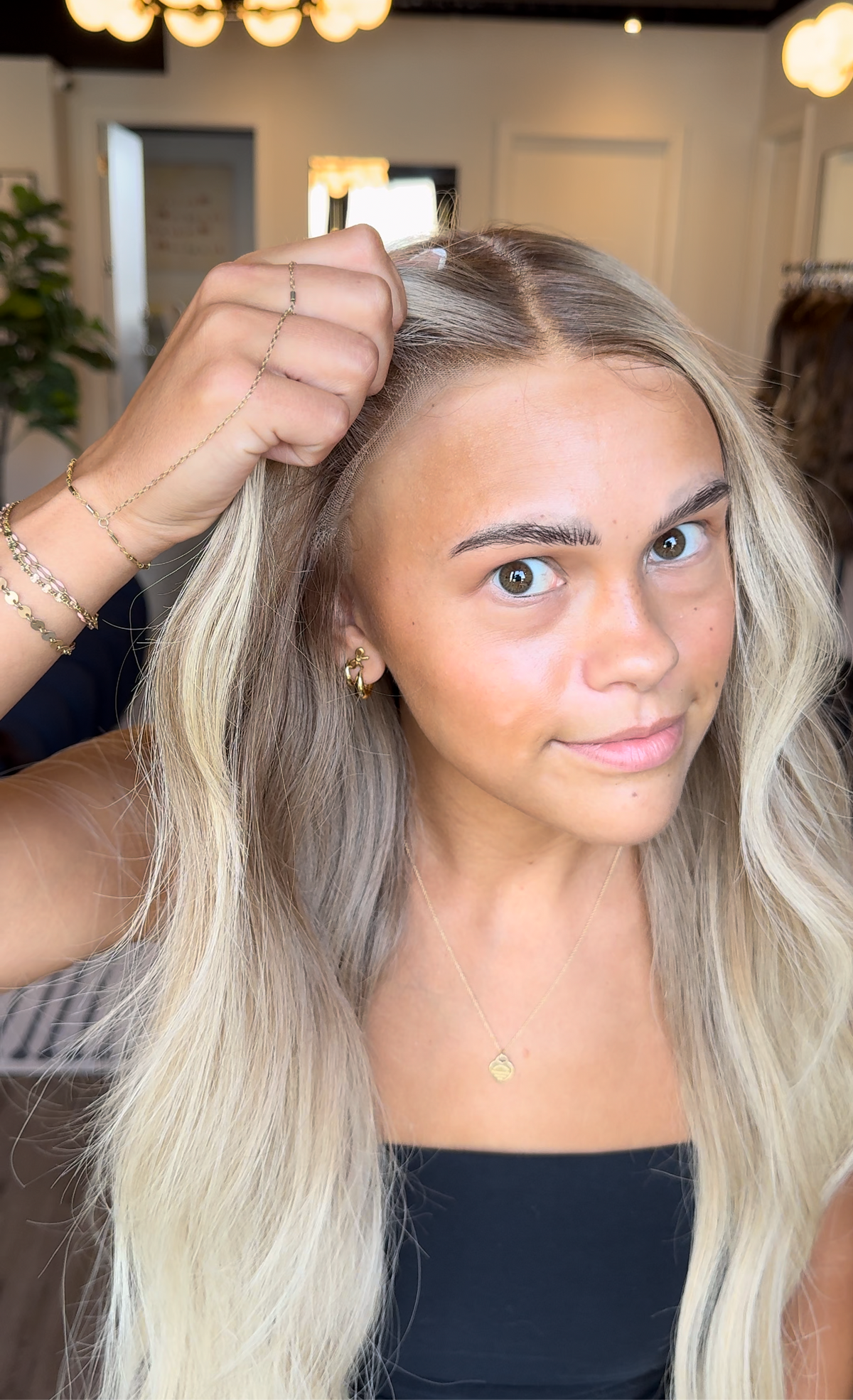 Model wearing blonde balayage 26-inch HD lace human hair wig in body wave
texture – Nuola Wigs.