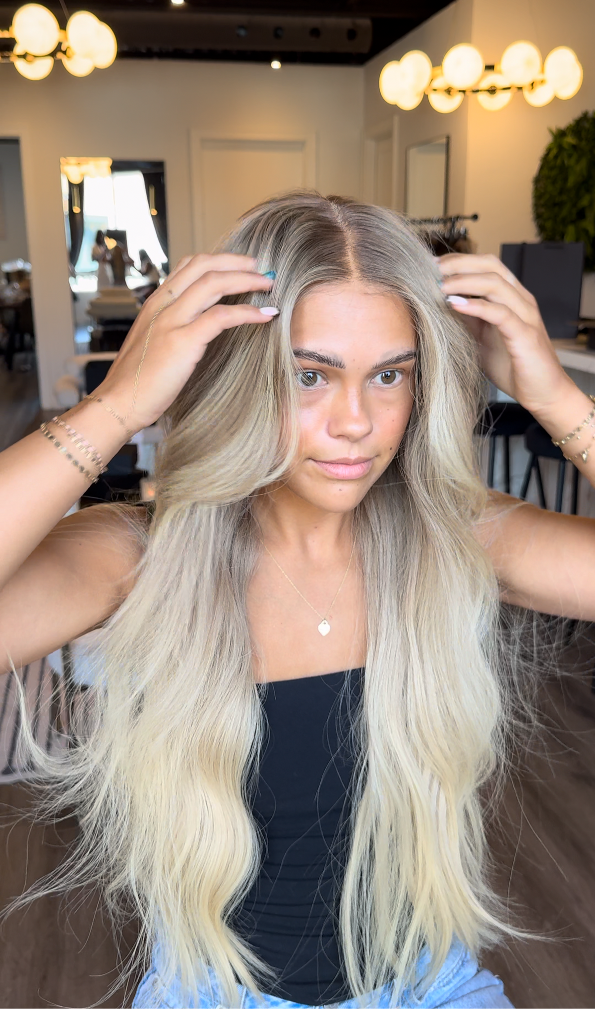 Model wearing blonde balayage 26-inch HD lace human hair wig in body wave
texture – Nuola Wigs.