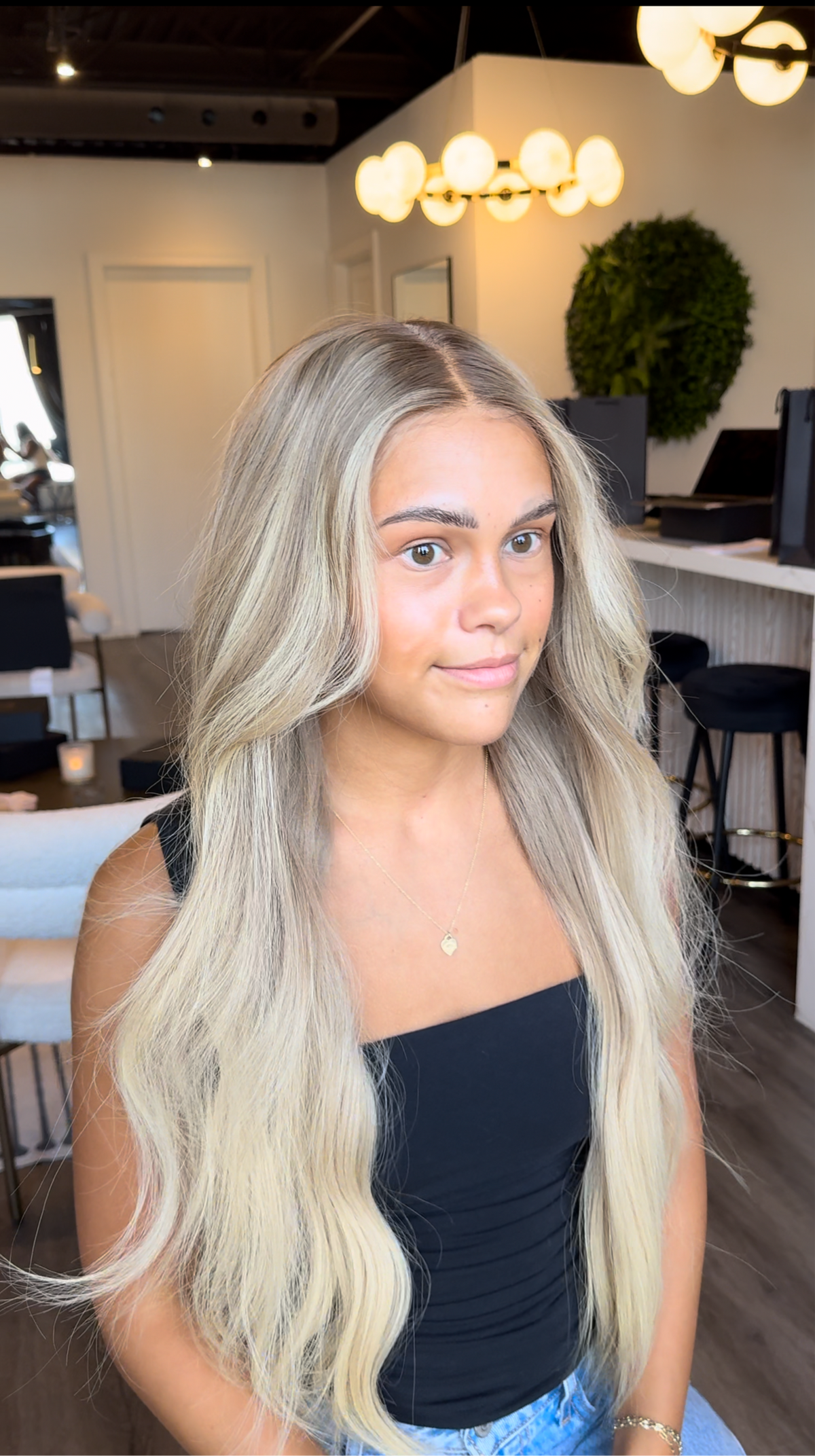 Model wearing blonde balayage 26-inch HD lace human hair wig in body wave
texture – Nuola Wigs.