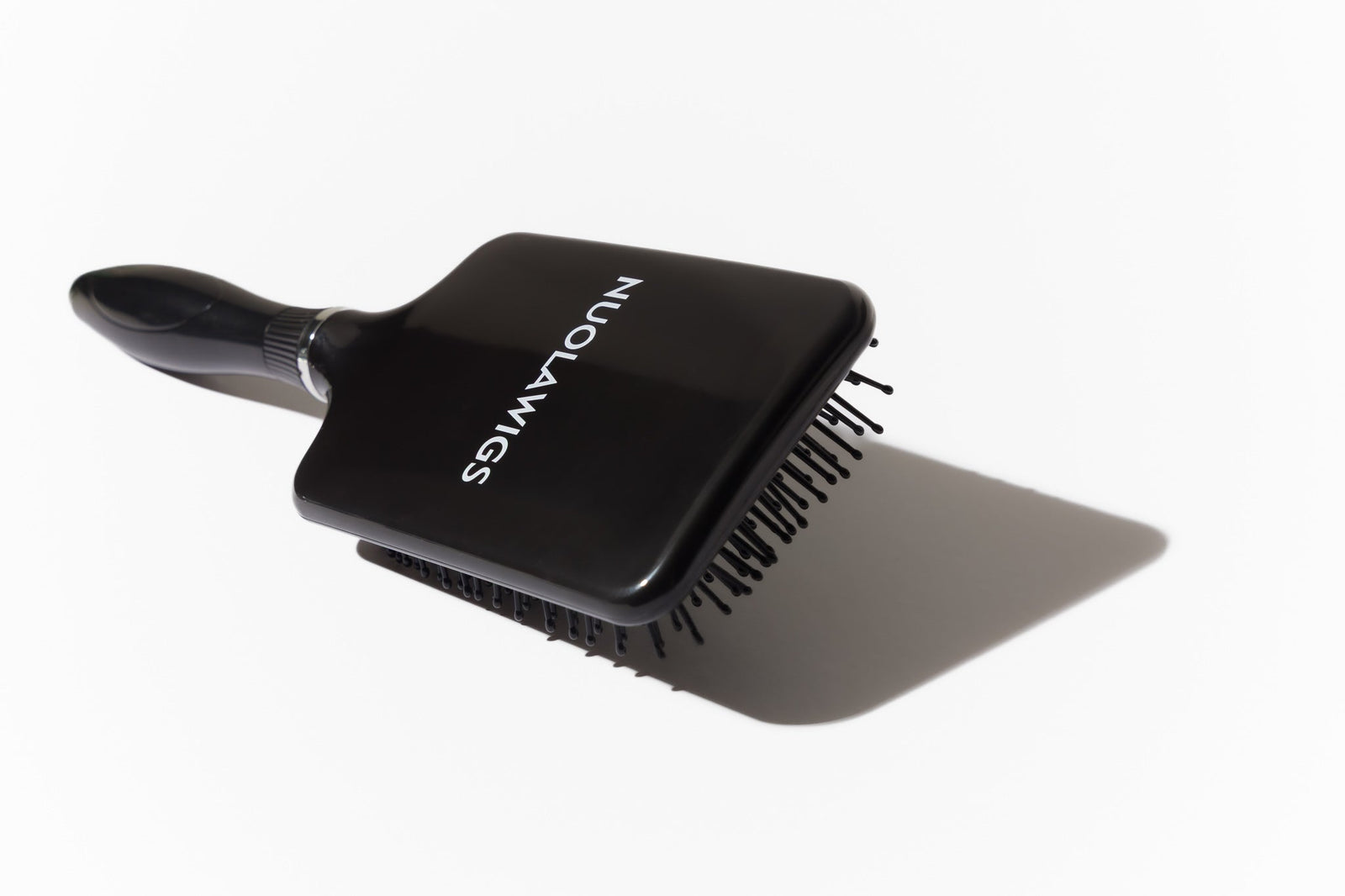 Model using soft bristle wig head brush to gently detangle and maintain wig fibres – Nuola Wigs.