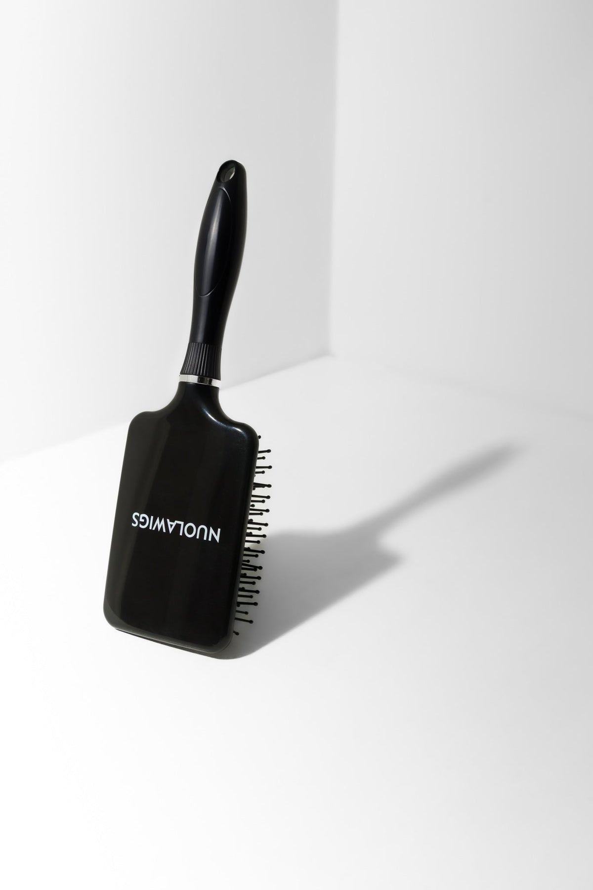 Model using soft bristle wig head brush to gently detangle and maintain wig fibres – Nuola Wigs.