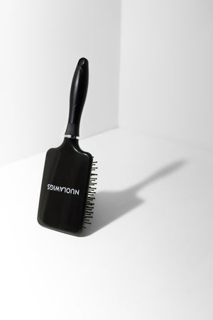 Model using soft bristle wig head brush to gently detangle and maintain wig fibres – Nuola Wigs.