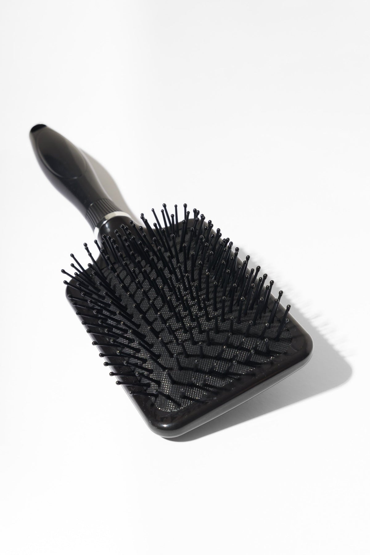 Model using soft bristle wig head brush to gently detangle and maintain wig fibres – Nuola Wigs.