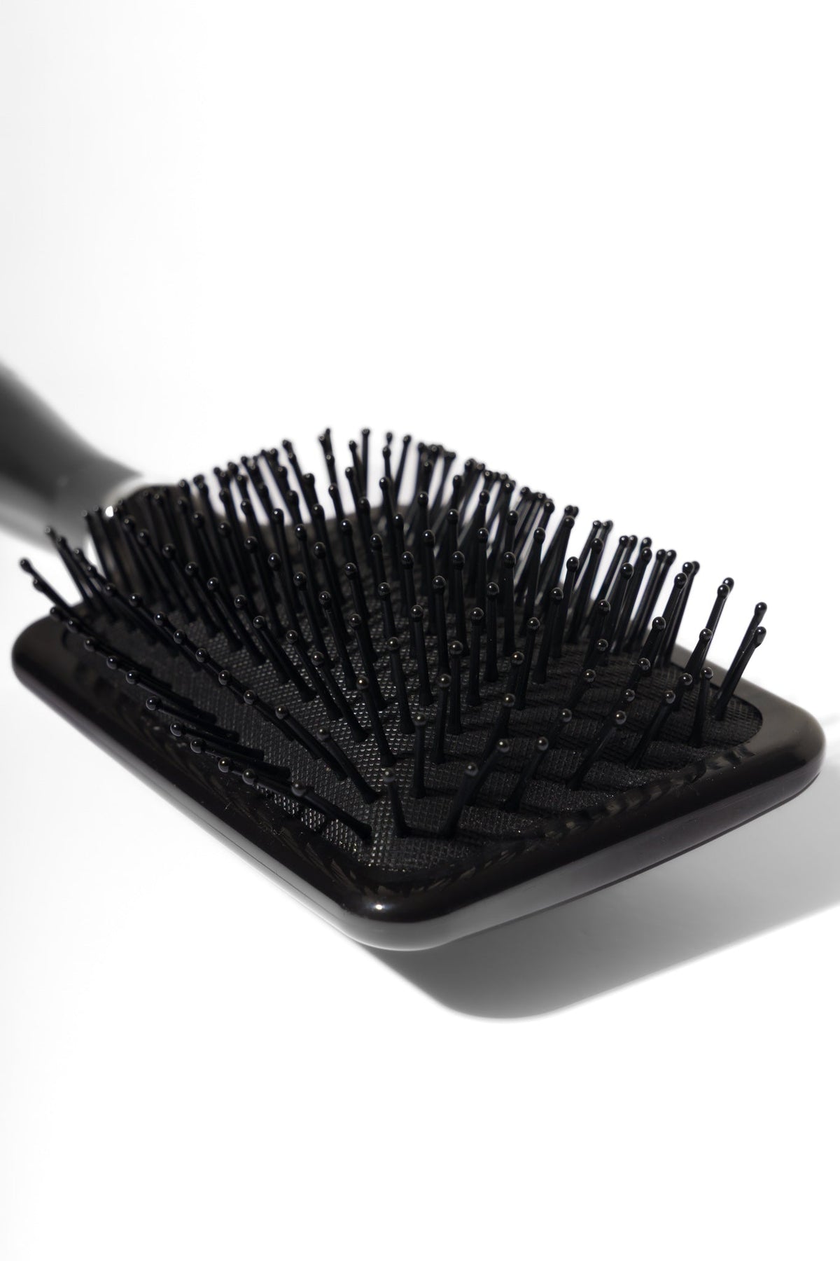 Model using soft bristle wig head brush to gently detangle and maintain wig fibres – Nuola Wigs.