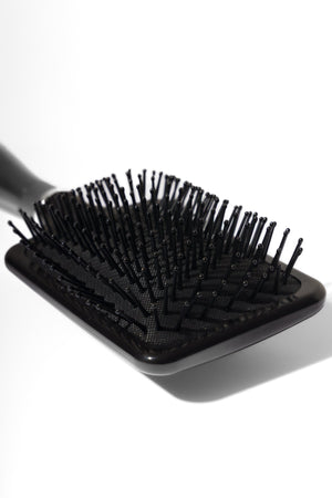 Model using soft bristle wig head brush to gently detangle and maintain wig fibres – Nuola Wigs.